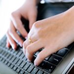 Close up of woman typing on keyboard